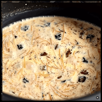 A warm bowl of homemade sweet vermicelli porridge garnished with chopped nuts and spices